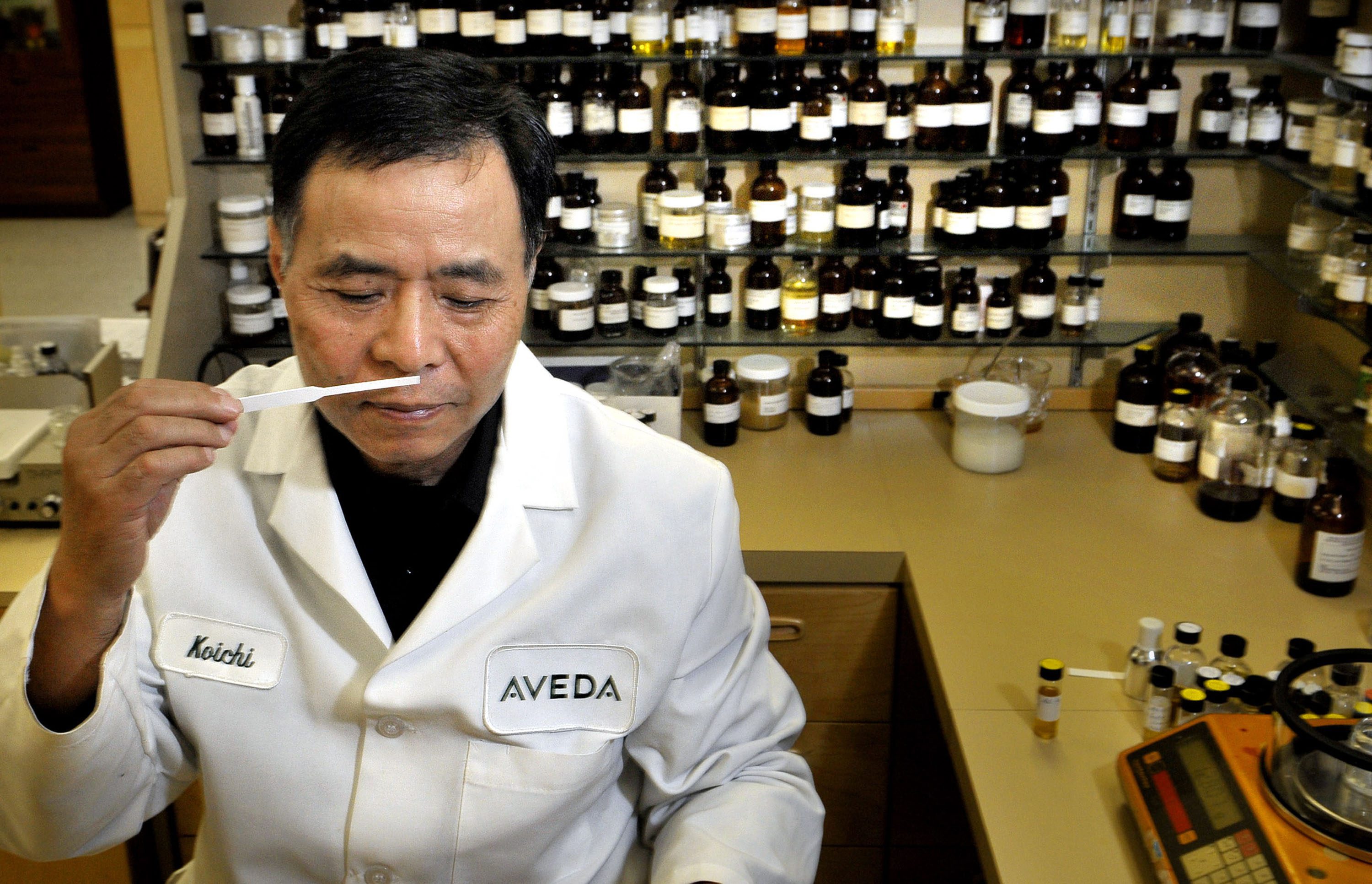 Ko-Ichi Shiozawa, chief perfumer at Aveda, smells a scent sample containing 15 essential oils that will be featured in a new Aveda shampoo and conditioner, available next year, at their Minnetonka, Minneapolis office, July 30, 2008. Behind him are samples of hundreds of essential oils. (Glen Stubbe/Minneapolis Star Tribune/MCT)