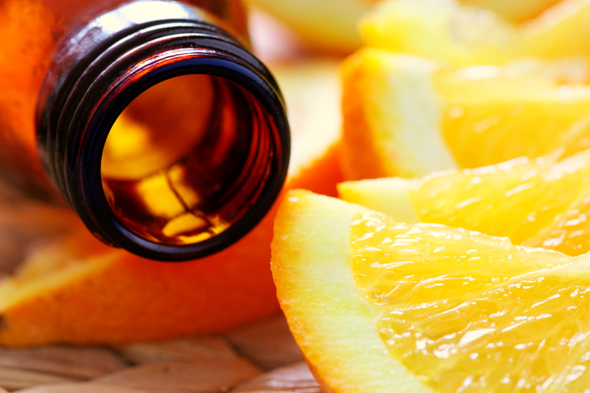bottle of aromatic essence and fresh oranges